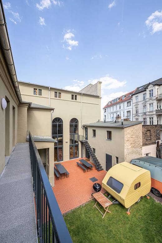 Blick vom Balkon in den Innenhof mit Wohnwagen