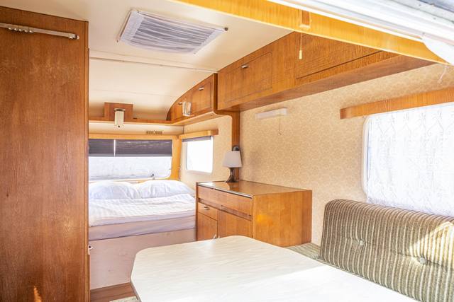 Im Wohnwagen: Doppelbett und Sitzecke