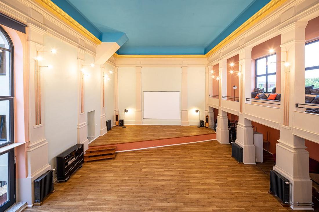 Saal mit Blick auf Bühne und Leinwand
