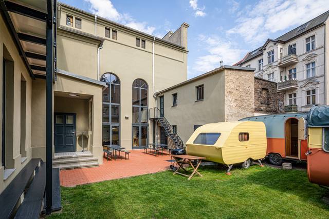 Innenhof mit Wohnwagen, dahinter das Raumquartier