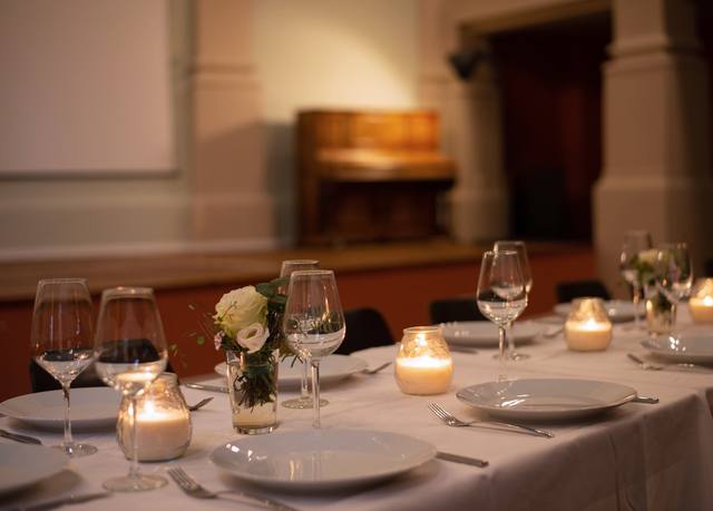 Gedeckter Tisch mit Kerzen, im Hintergrund das Klavier